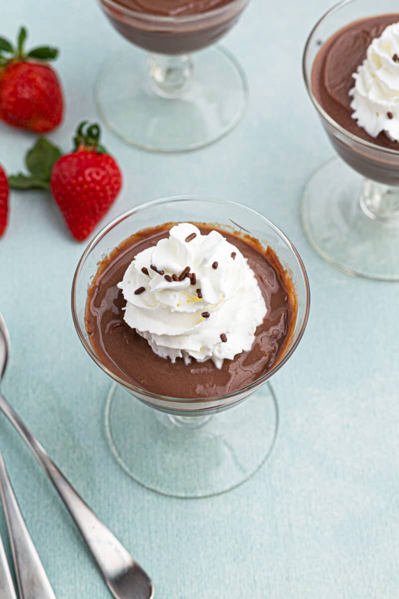 chocolate pudding topped with whipped cream in cups