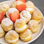 a plate of pastries with strawberries and powdered sugar.