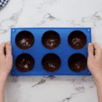 a silicone half-sphere mold filled with chocolate.