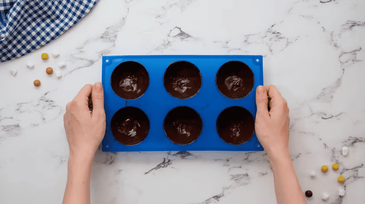 a silicone half-sphere mold filled with chocolate.