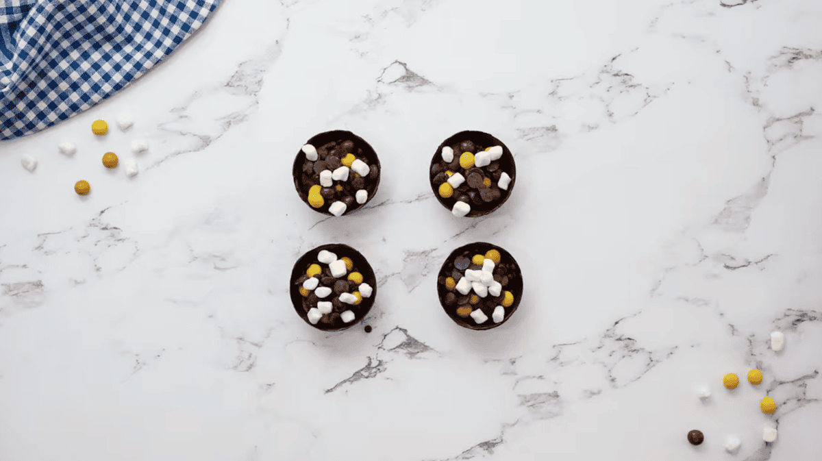 4 chocolate half-spheres filled with hot cocoa mix, chocolate chips, and marshmallows.