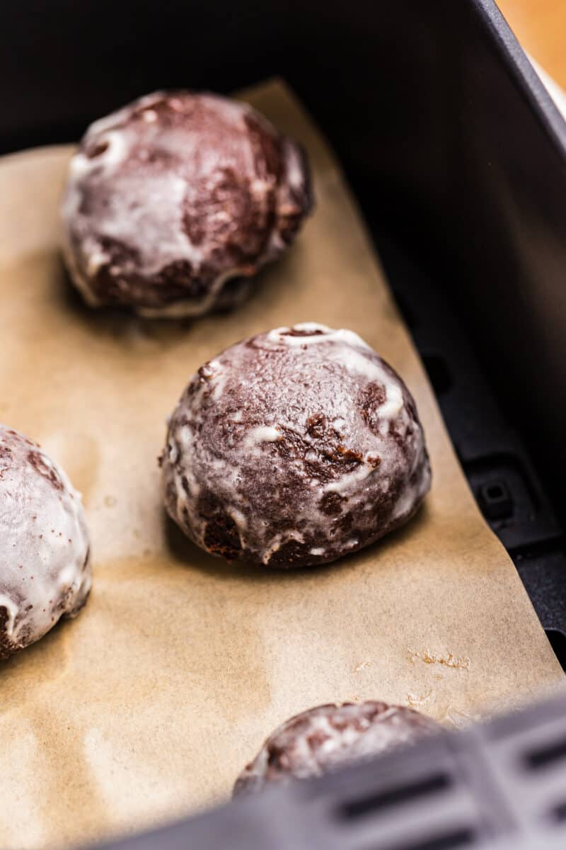 glazed chocolate donut holes made in an air fryer on parchment