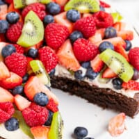 brownie fruit pizza topped with cream and sliced fruit