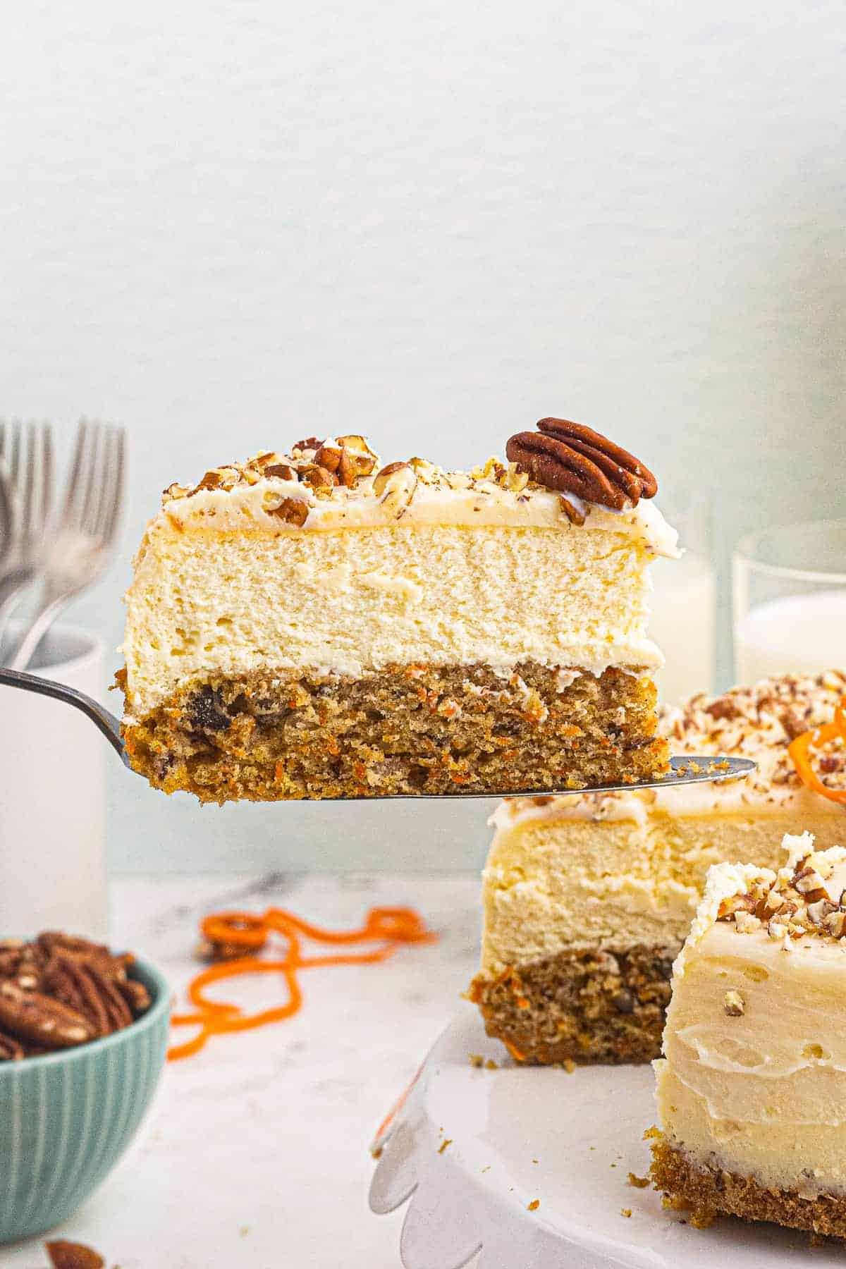 lifting up slice of carrot cake cheesecake