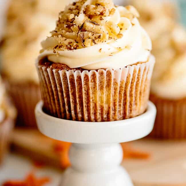 carrot cake cupcake garnished with nuts on cupcake stand
