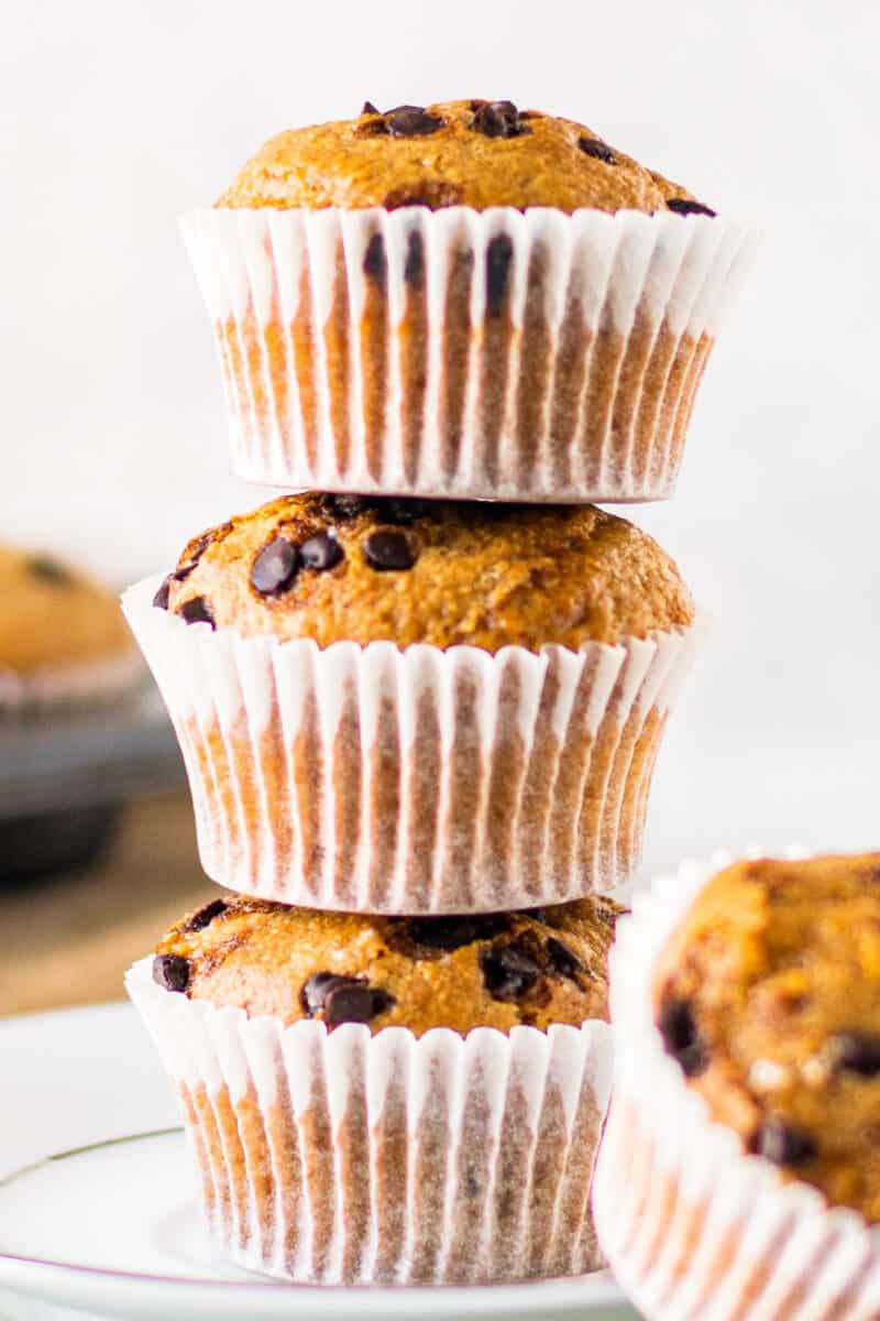 up close stacked chocolate chip muffins on white plate