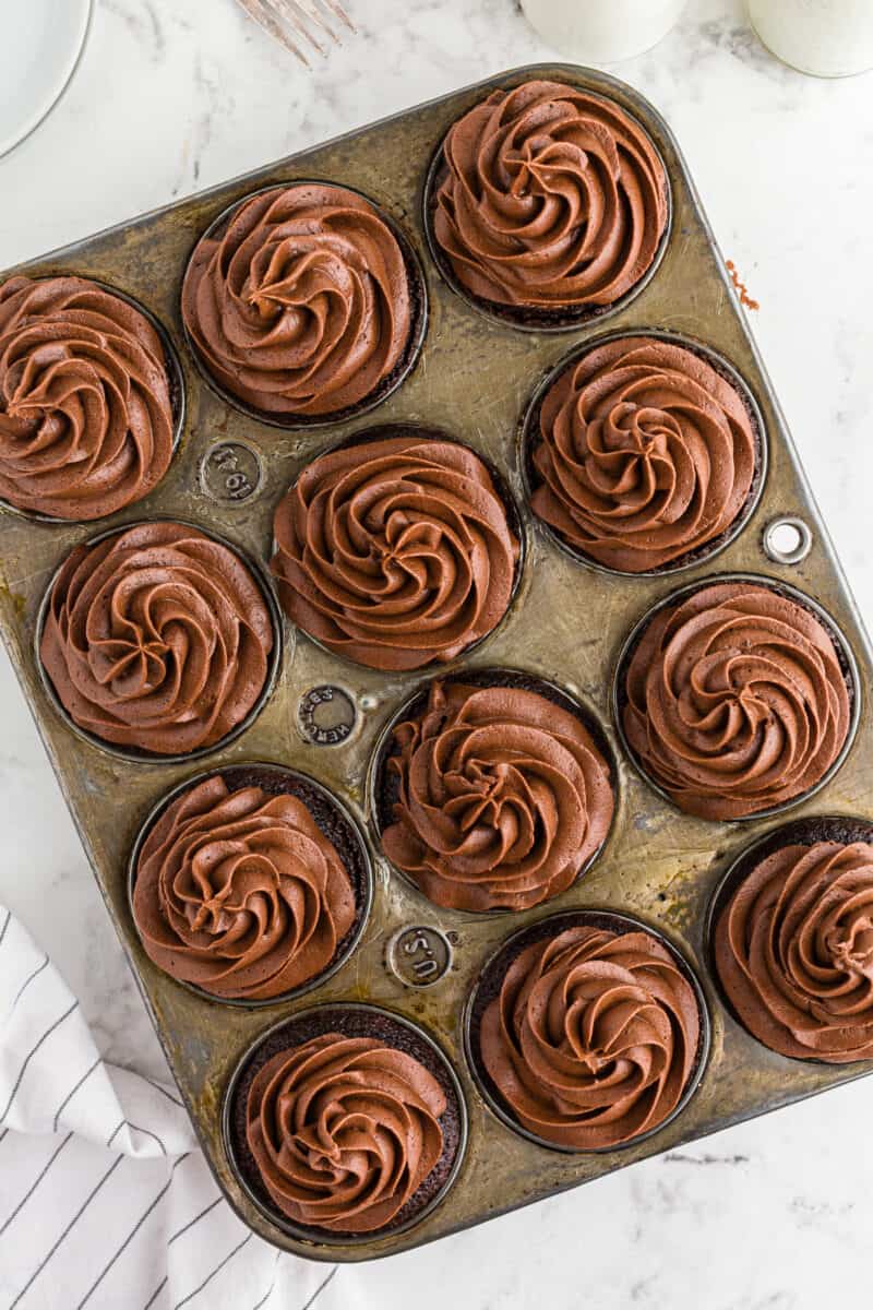 overhead chocolate cupcakes with chocolate buttercream in cupcake tin