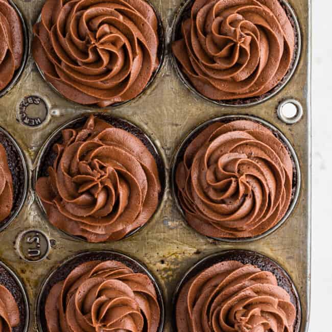 overhead chocolate cupcakes with chocolate buttercream in cupcake tin