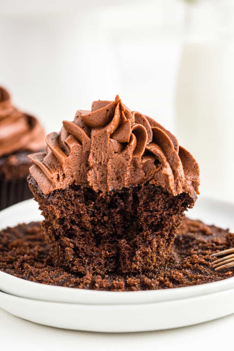 bite out of chocolate cupcake on white plates