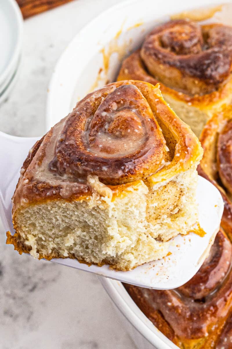 holding up cinnamon roll with serving spatula