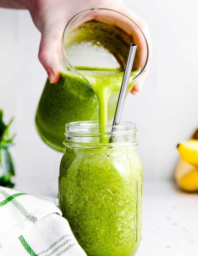 pouring an island green smoothie into a glass jar