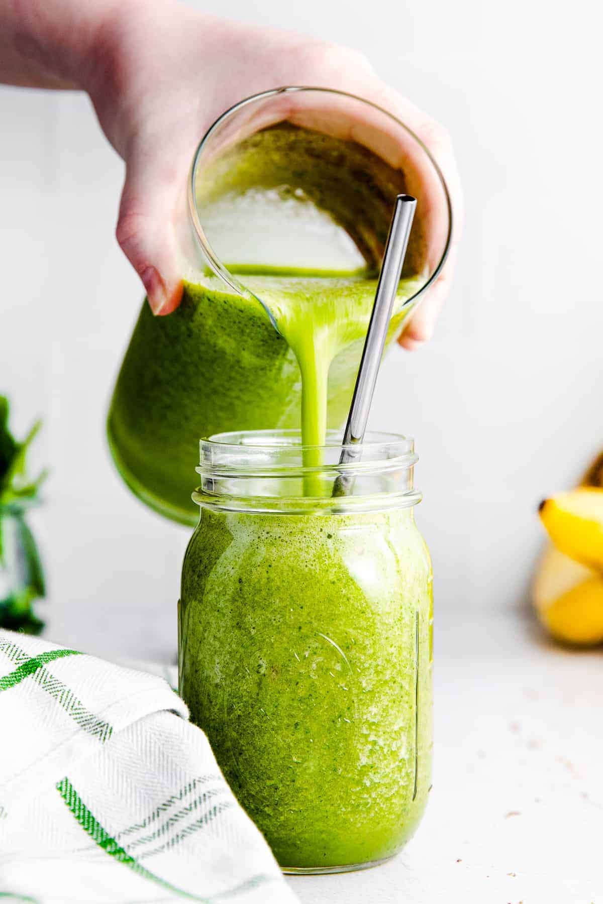 pouring an island green smoothie into a glass jar