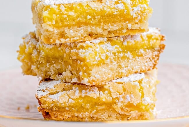 stacked lemon bars on pink plate