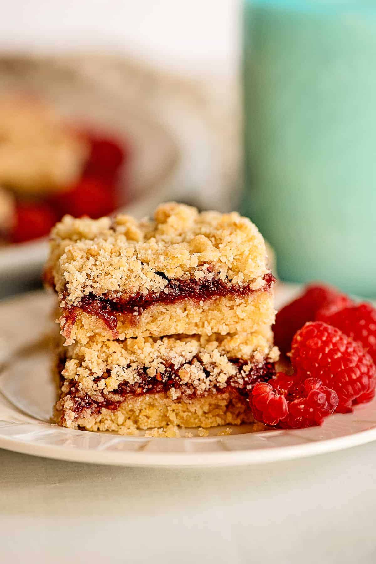 stacked raspberry crumb bars on white plate