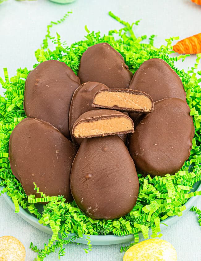 homemade reese's peanut butter eggs over fake grass with one cut in half