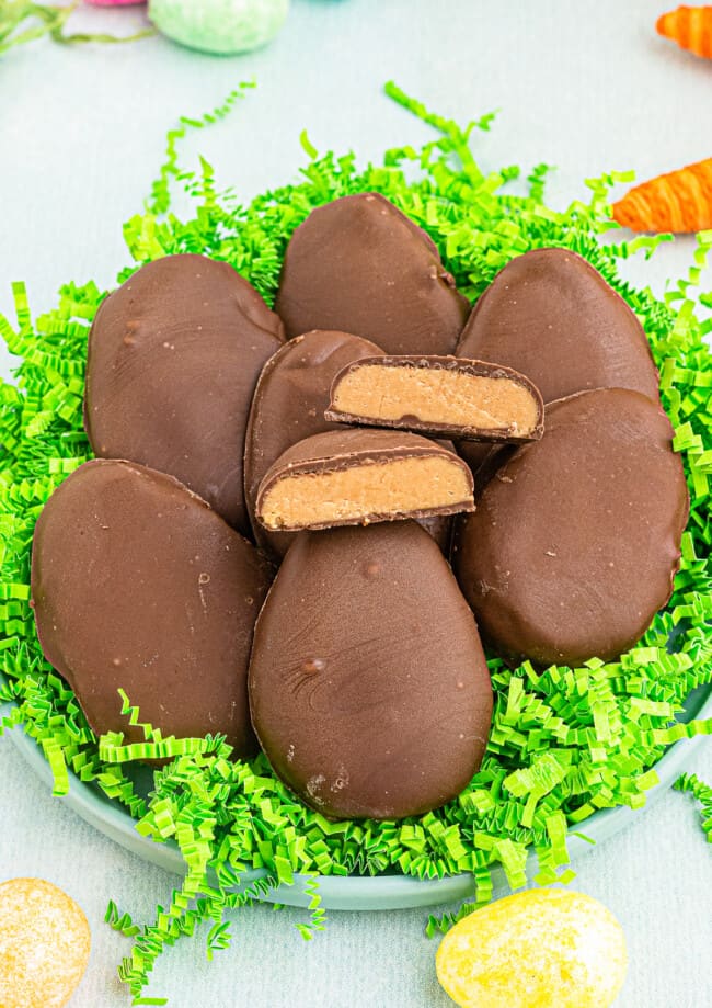 homemade reese's peanut butter eggs over fake grass with one cut in half