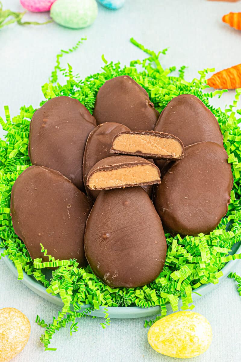 homemade reese's peanut butter eggs over fake grass with one cut in half