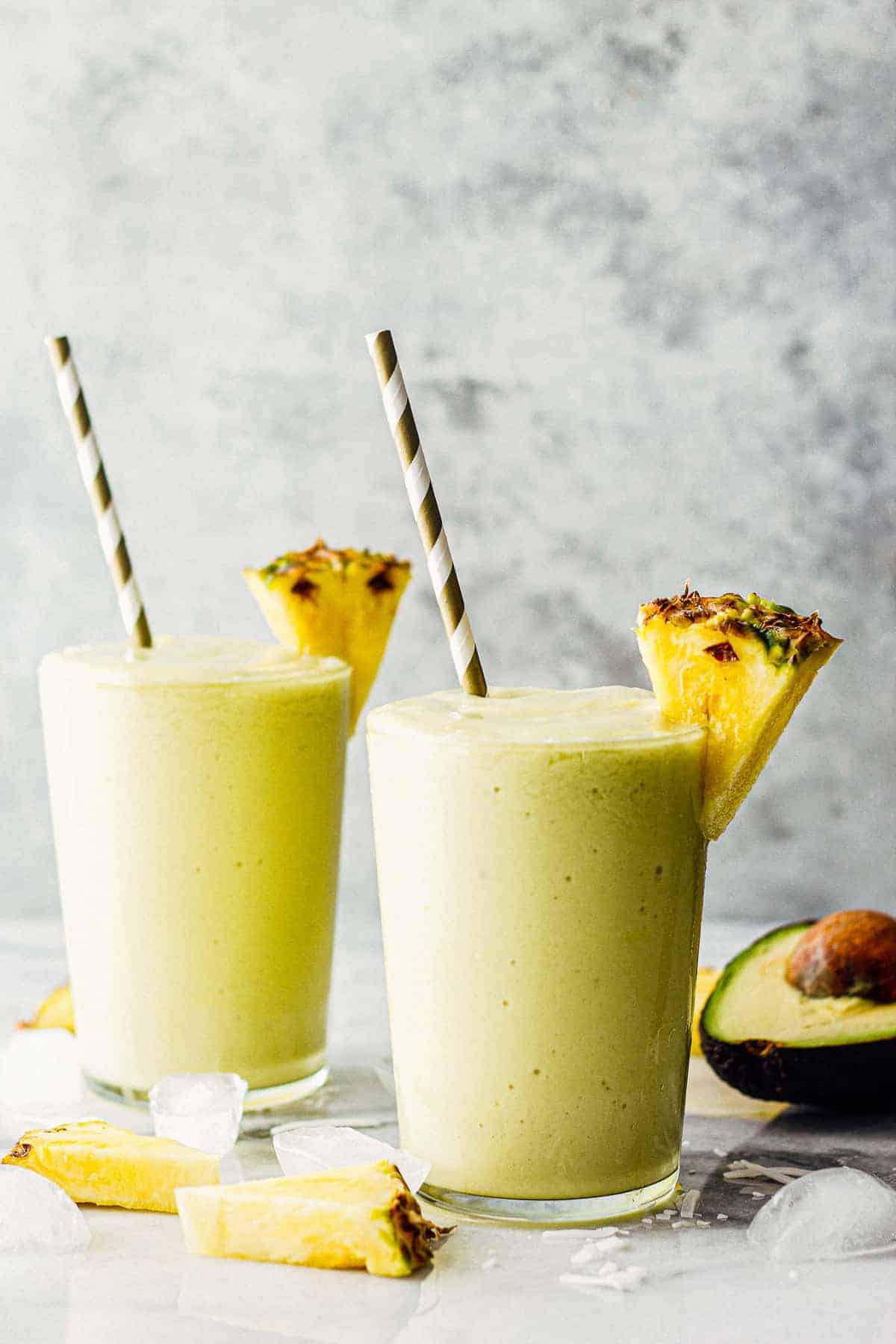 two pineapple avocado smoothies in glasses