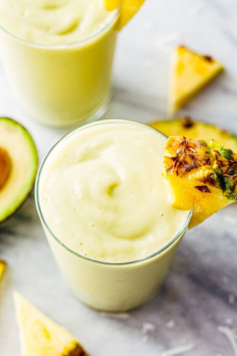 overhead image of two pineapple avocado smoothies