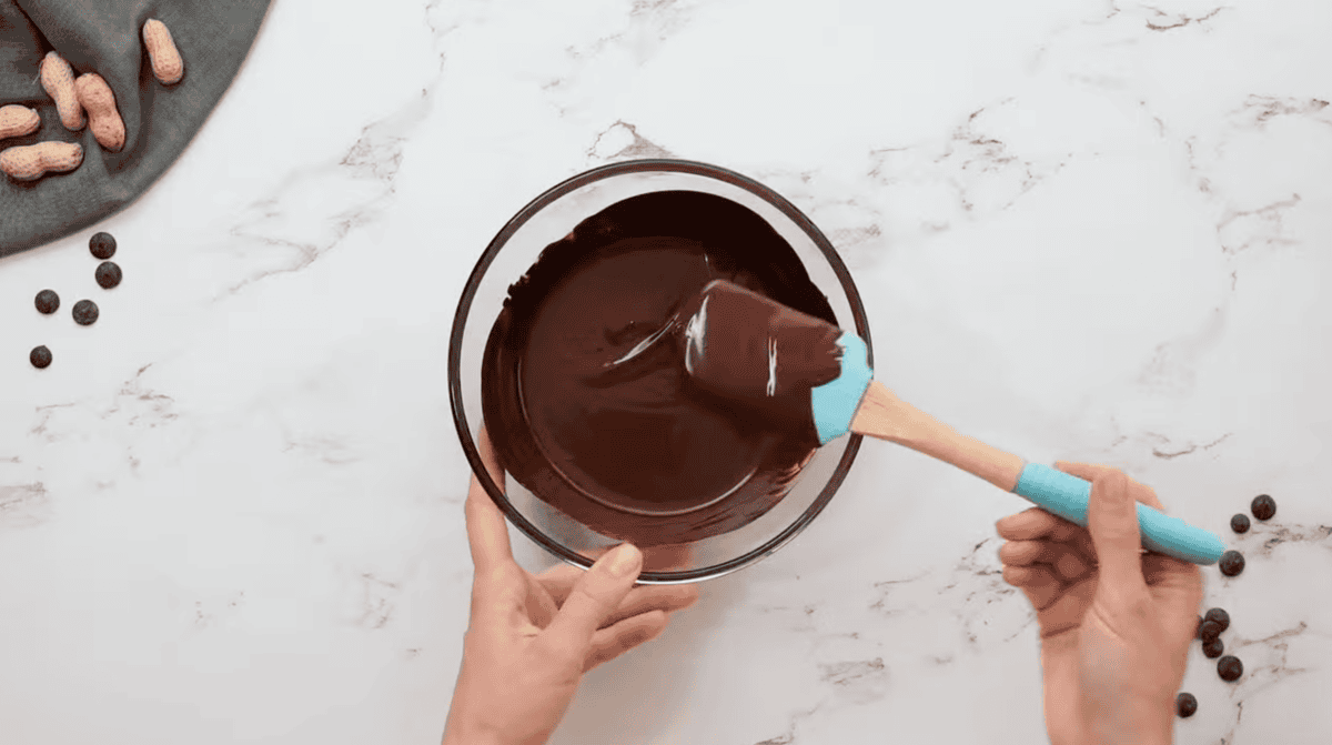 melted chocolate in a glass bowl with a rubber spatula.