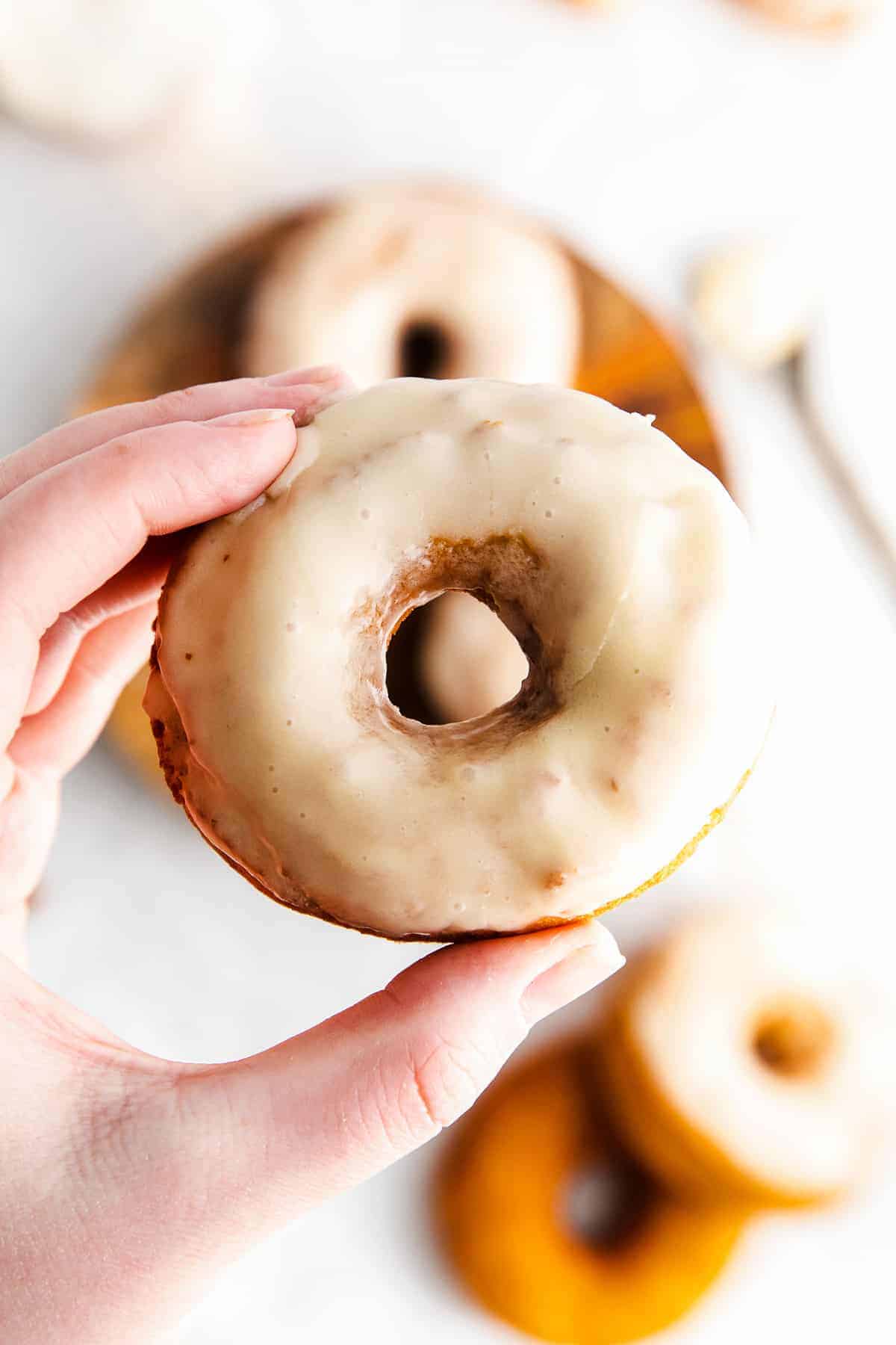 holding up a glazed donuts