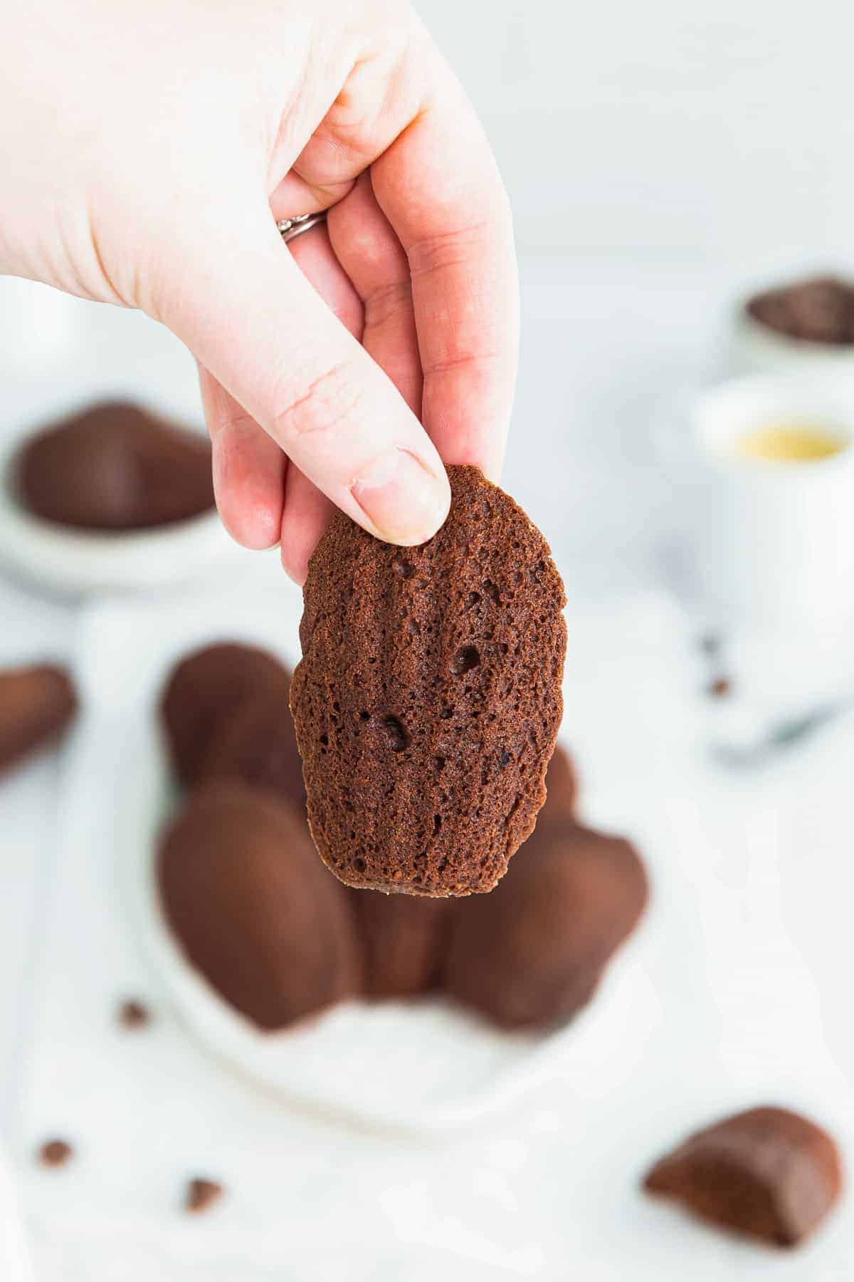 holding up chocolate madeleine cookie