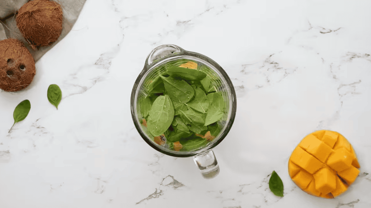 tropical green smoothie ingredients in a blender.