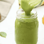 pouring an island green smoothie into a mason jar.