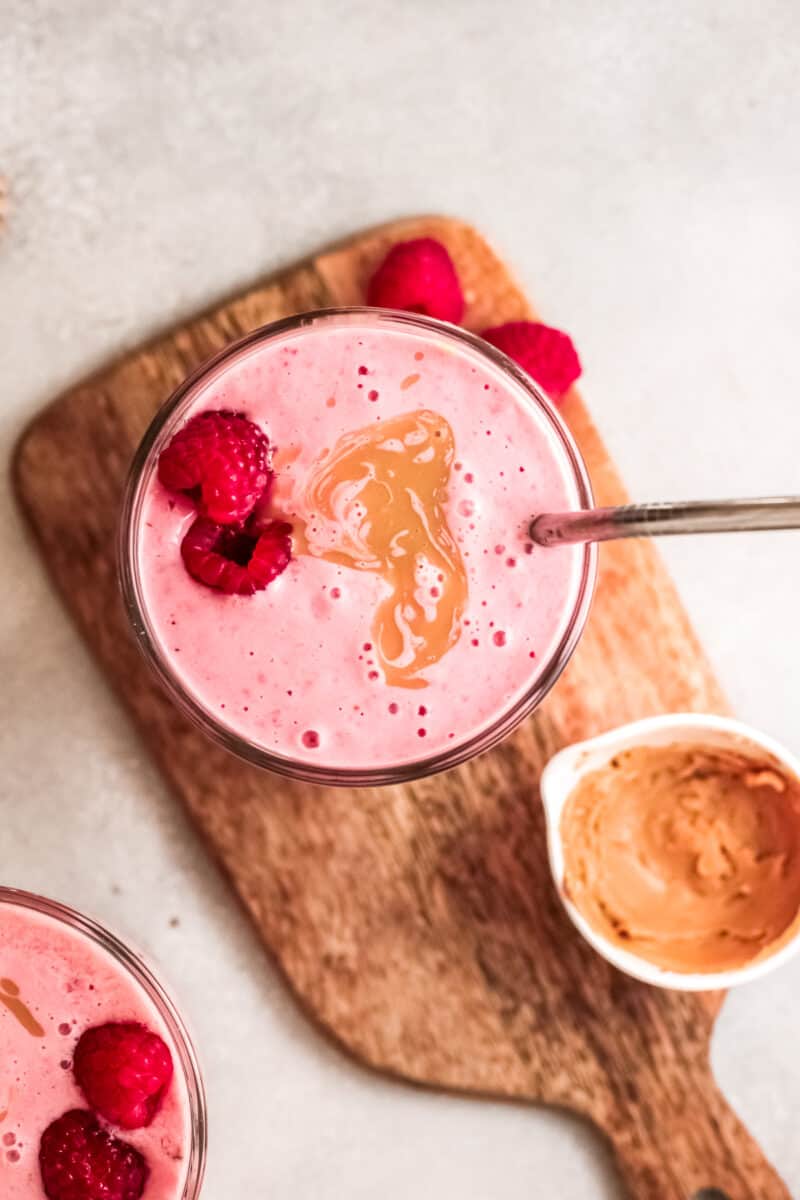 overhead peanut butter and jelly smoothies garnished with raspberries and peanut butter