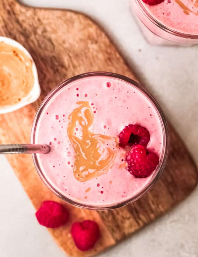 overhead peanut butter and jelly smoothies garnished with raspberries and peanut butter