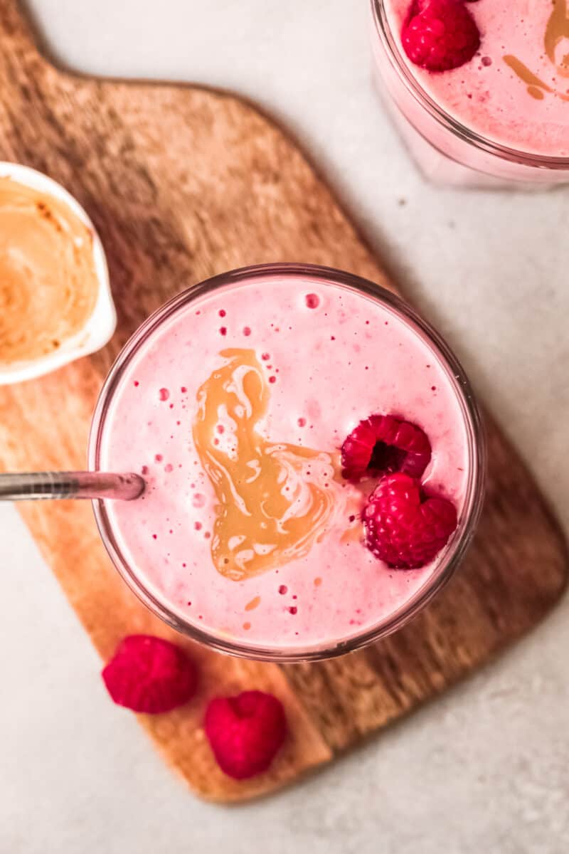 overhead peanut butter and jelly smoothies garnished with raspberries and peanut butter