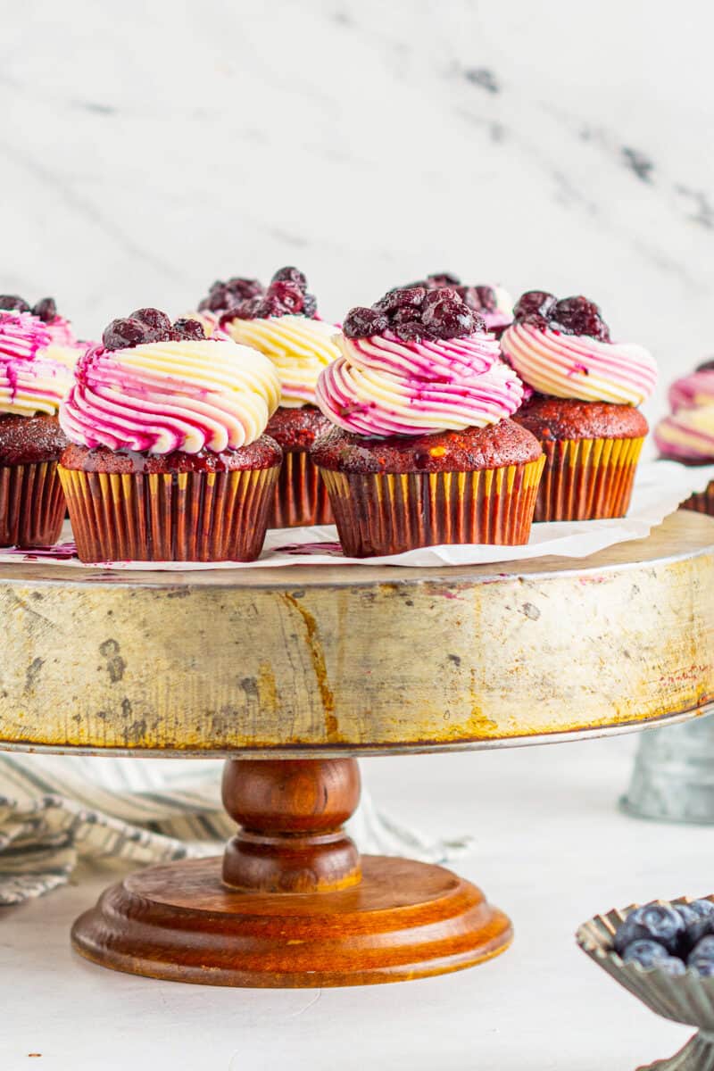 cake stand with red velvet cupcakes with blueberry cupcakes