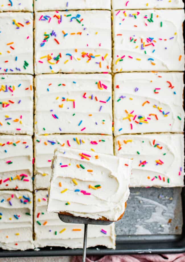 sliced vanilla sheet cake with frosting and sprinkles