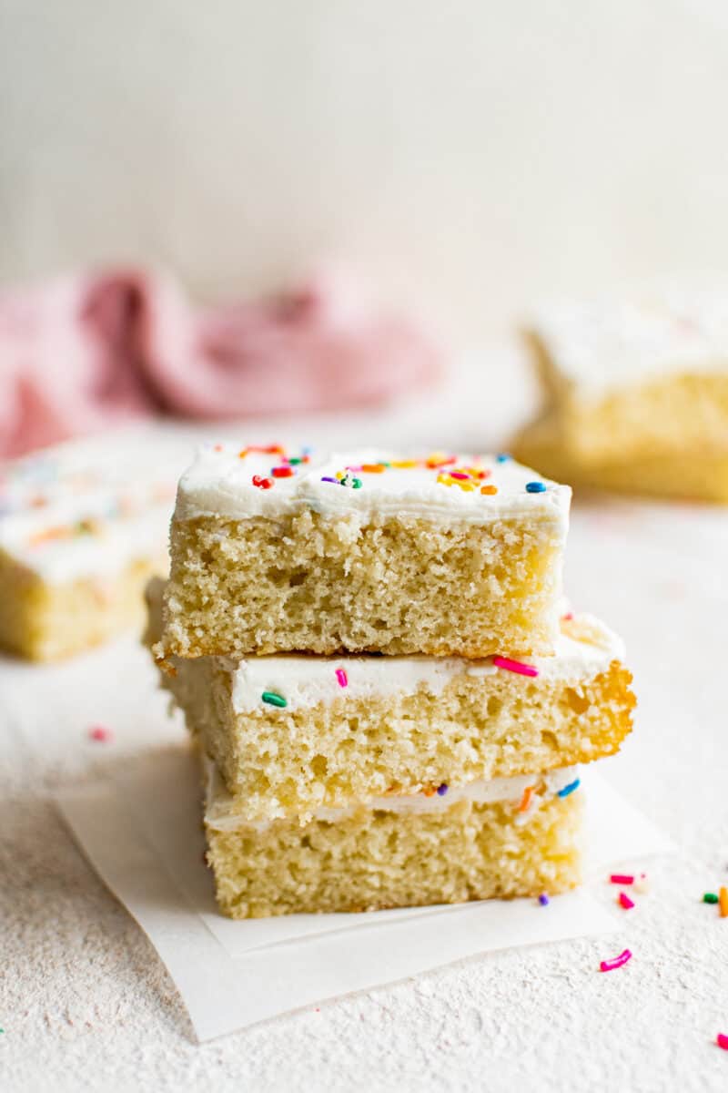 stacked slices of vanilla sheet cake with frosting and sprinkles