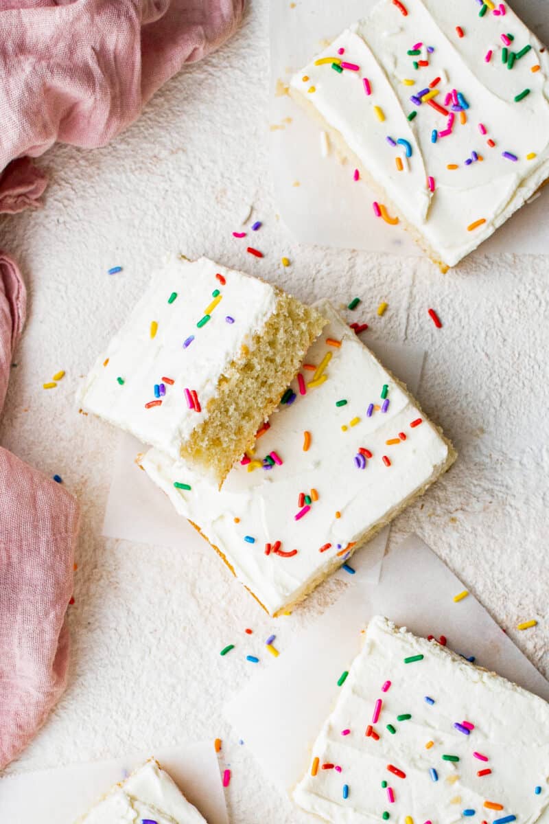 stacked slices of vanilla sheet cake with frosting and sprinkles