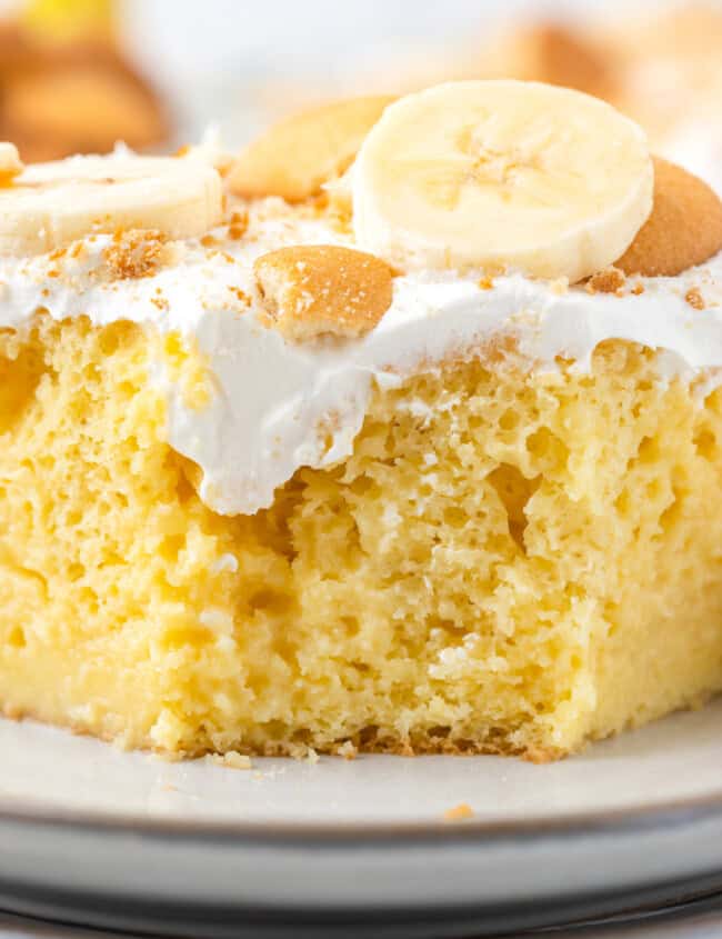 slice of banana cream pie poke cake on a white plate