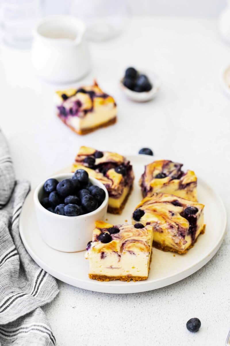 blueberry cheesecake bars on a white plate