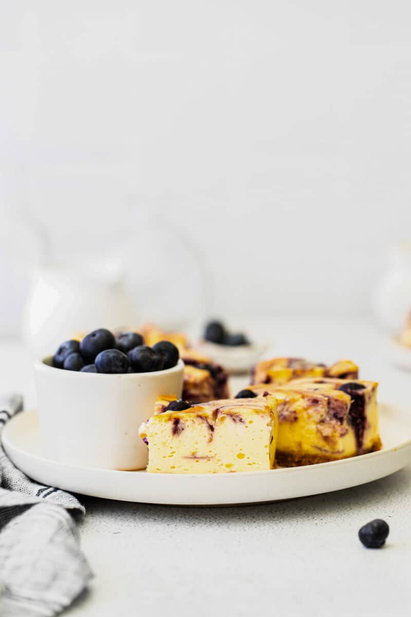 blueberry cheesecake bars on a white plate