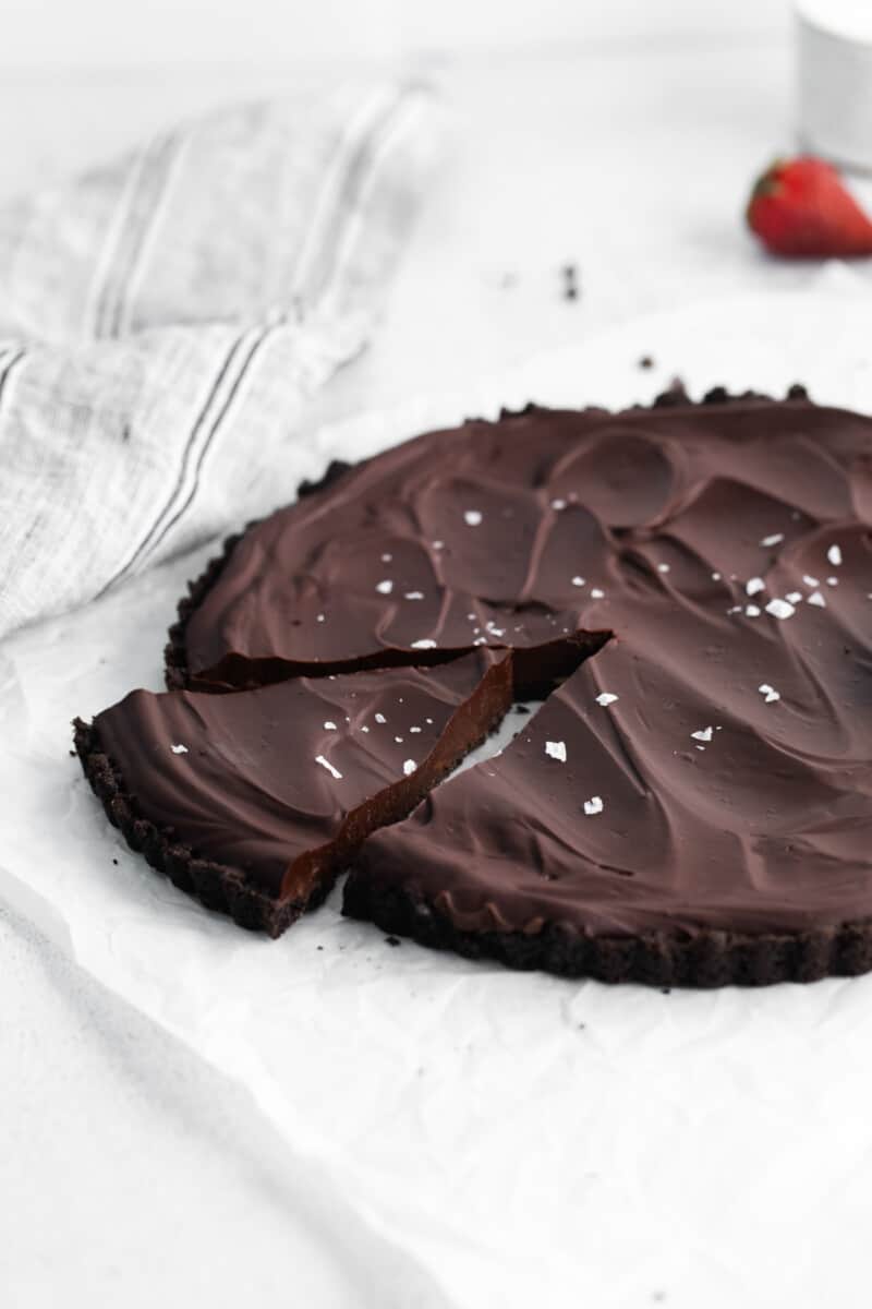 chocolate tart with one slice cut.