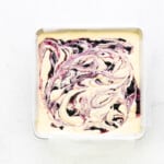 blueberry swirled cheesecake batter in a square pan before baking