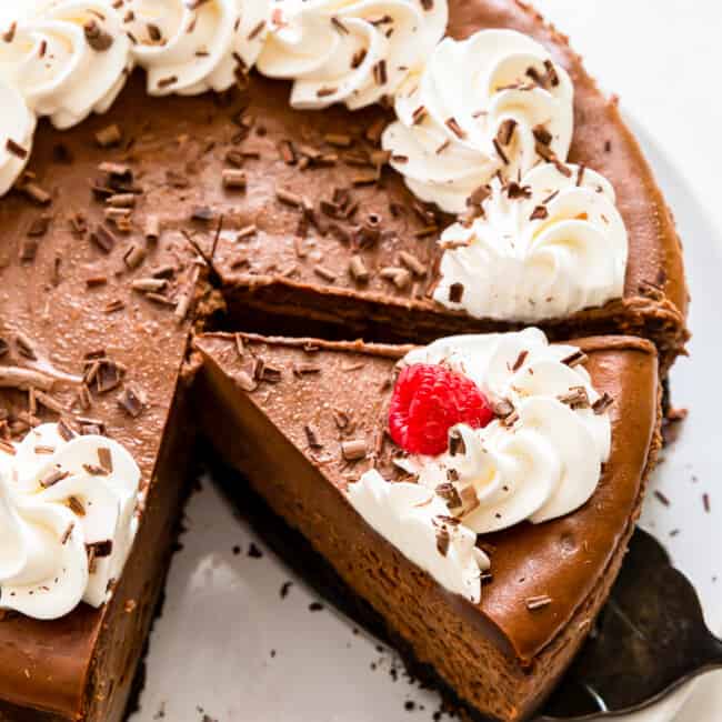 chocolate cheesecake with whipped cream and raspberries