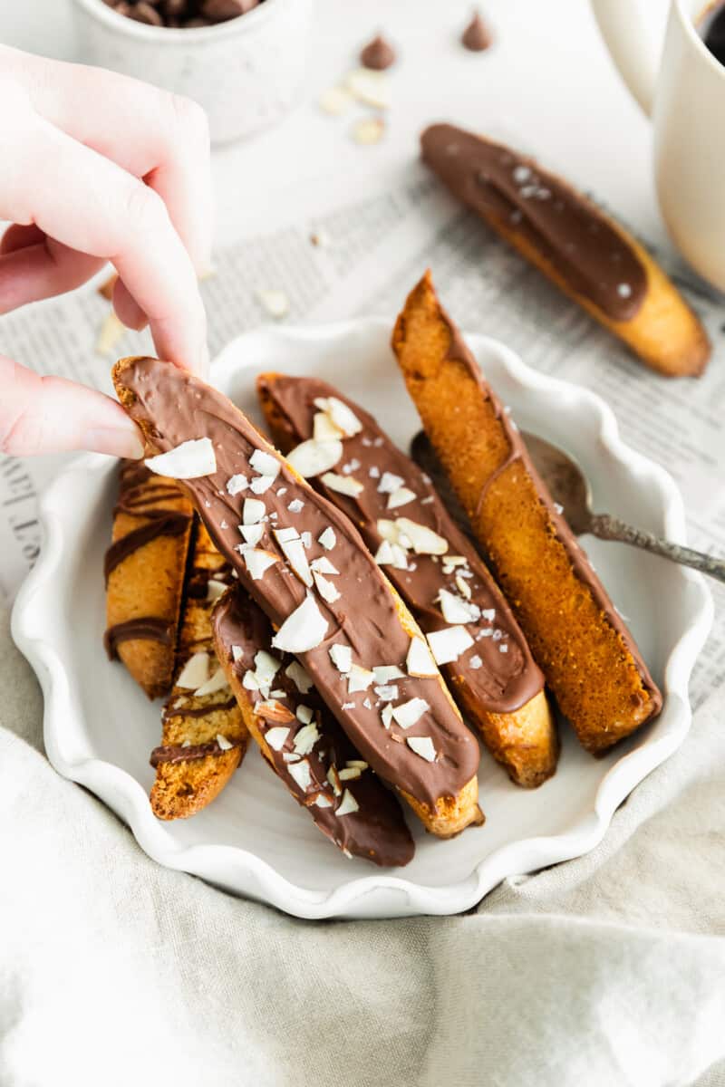 hand lifting up chocolate dipped biscotti