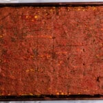 a baking pan with a square of brownies on it.