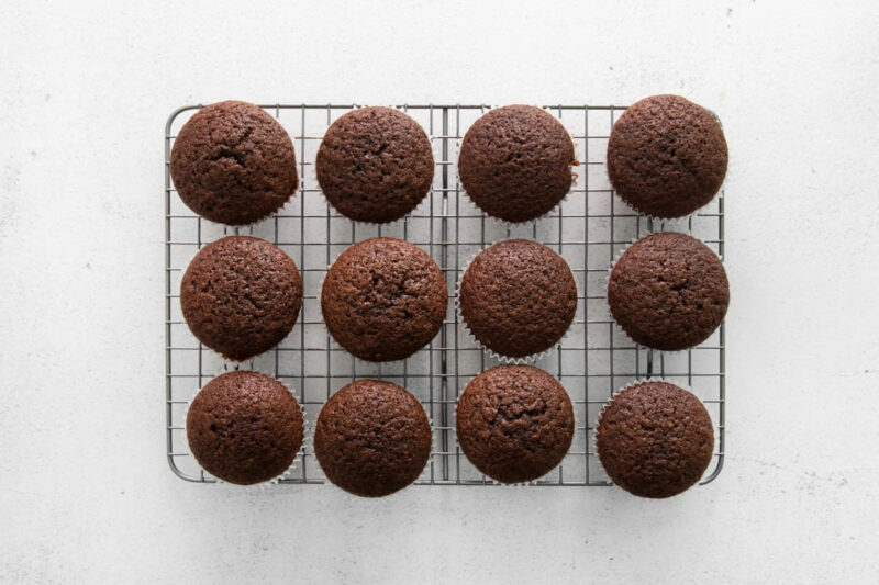 baked chocolate cupcakes on a wire rack.