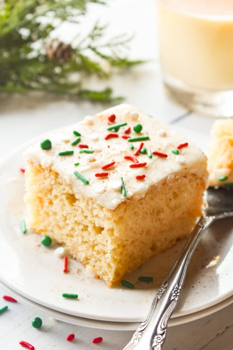 a slice of eggnog sheet cake on a white plate with a fork.