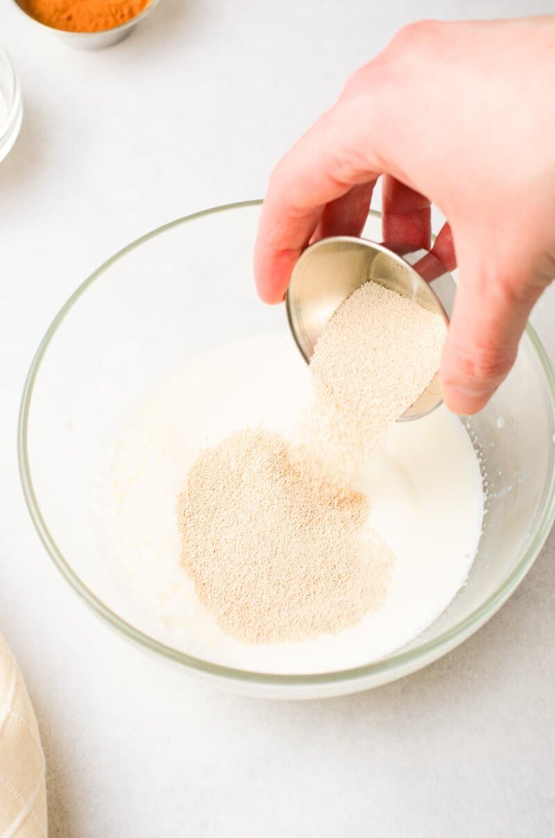 yeast added to lukewarm milk and sugar in a glass bowl.