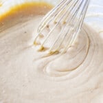 eggnog sheet cake batter in a glass bowl with a whisk.