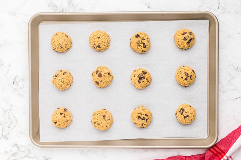 12 unbaked copycat mrs fields chocolate chip cookies on a baking sheet.