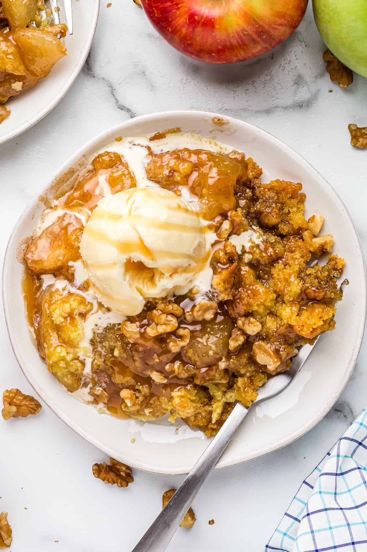 white plate with caramel apple dump cake and ice cream