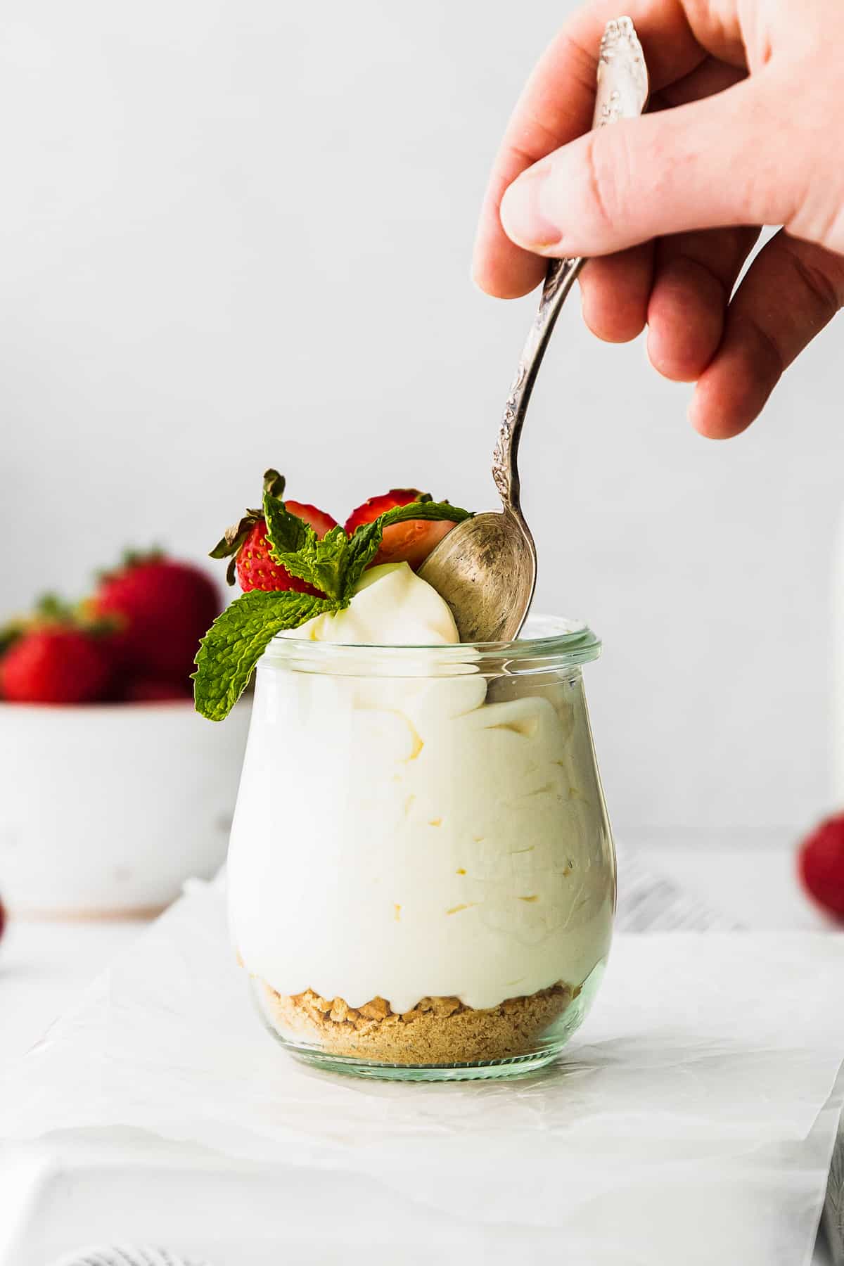 spoon in cheesecake mousse topped with strawberries